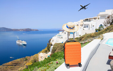The travel concept with Orange luggage and hat as landscape view of Oia town in Santorini island in Greece