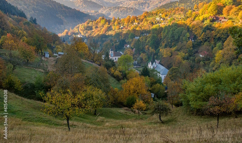 Romantic small village in the valley in sunny autumn weather. The old mining village of Hodrusa with historic churches near Banska Stiavnica.  photo