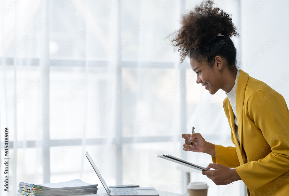 business concept african american business woman The file works on a laptop computer. Documents on folder business working background, tax, accounting, statistics and analytic research concept. business concept african american business woman The file works on a laptop computer. Documents on folder business working background, tax, accounting, statistics and analytic research concept.