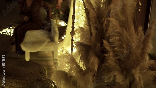 Slow revealing shot of pampas grass set out beside a wedding chair set photo