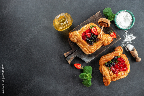 yummy berry puff pastry with berries on a dark background. banner, menu, recipe place for text, top view