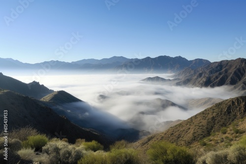 panoramic view of mist-shrouded mountains, bordered by a blue sky, created with generative ai © Natalia