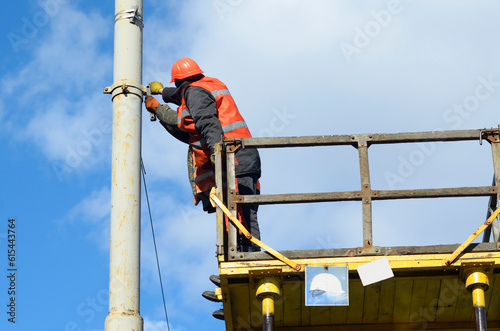Man ironworker repairing trolleybus rigging standing on a truck mounted lift photo