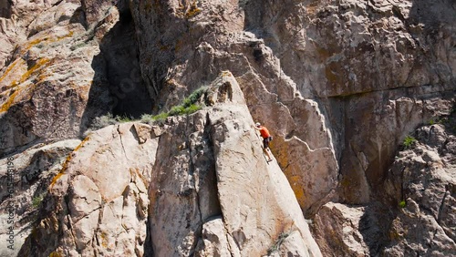 Man athlette climbing on the high rock photo