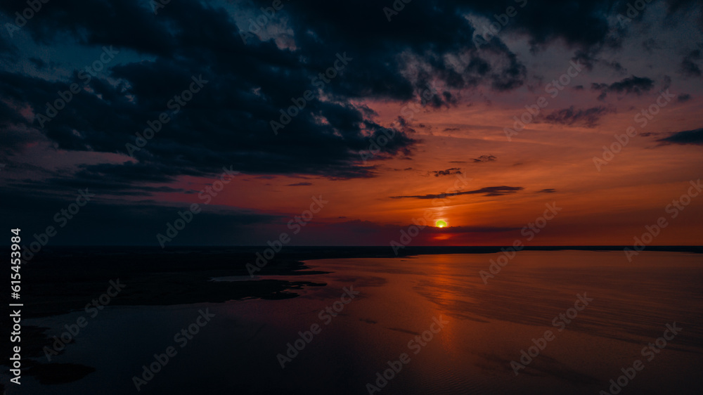Red sunset by the lake. Hot weather at sunset. Dramatic red sunset at desert. Heatwave hot sun. Climate Change. Global Warming. Red sunset by the lake. Hot weather at sunset. Dramatic red sunset at desert. Heatwave hot sun. Climate Change. Global Warming.