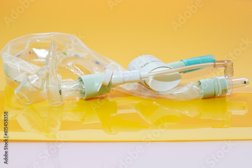 Closed suction system for intubated, ventilated neonates and pediatric patients with protective sleeve to isolate pathogens inside and avoid cross-infection on yellow background photo