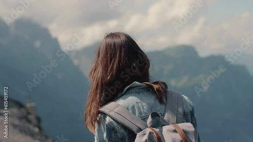 Cinematic close-up of young attractive Caucasian female hiking and smiling to camera with mointains view in background photo