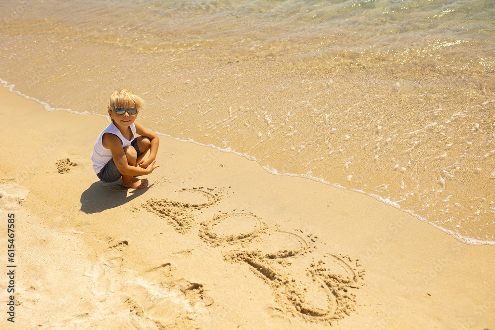 Child, playing on the beach in the sand, enjoying summer, number sign Child, playing on the beach in the sand, enjoying summer, number sign