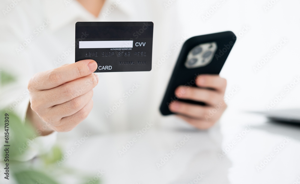 Close up view, young asian woman holding credit card and smart phone to shopping online and paying her order, People relax on holiday use technology from smart phone for the convenience of daily use