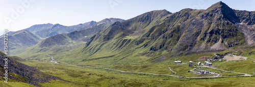 Independence Mine State Historical Park Visitor Center surrounded by the Talkeetna Mountains across Hatcher Pass under a sunny, blue sky; Palmer, Alaska, United States of America