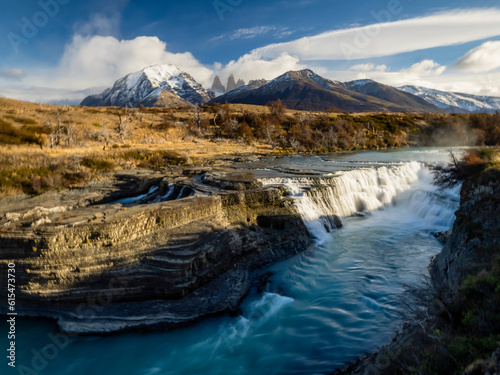 Scenic view of Cascada Rio Paine with the Cuernos Del Paine mountain peaks in the distance; Torres del Paine National Park, Patagonia, Chile photo