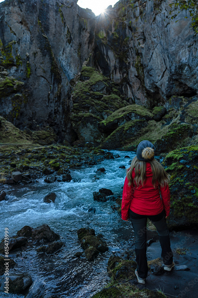 View taken from behind of a woman exploring the canyons and scenery of Thorsmork, an area of exceptional beauty in Southern Iceland; Thorsmork, South Coast, Iceland View taken from behind of a woman exploring the canyons and scenery of Thorsmork, an area of exceptional beauty in Southern Iceland; Thorsmork, South Coast, Iceland