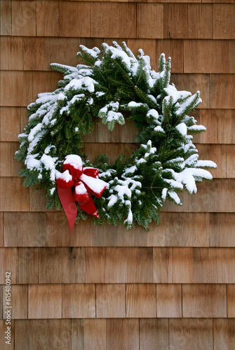 Snow-dusted evergreen wreath on a wood facade; Lake Placid, New York, United States of America