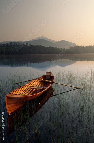 Boat with oars floating on a tranquil lake a twilight in Adirondack Park, New York, USA; New York, United States of America photo