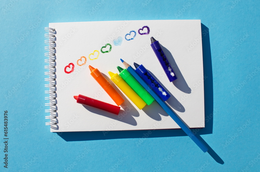 Hearts drawn with colored pencils Children's drawing Row rainbow hearts on white page on blue background Symbol LGBT flag It's okay to be different Emotions feelings Love Empty space for your text Hearts drawn with colored pencils Children's drawing Row rainbow hearts on white page on blue background Symbol LGBT flag It's okay to be different Emotions feelings Love Empty space for your text