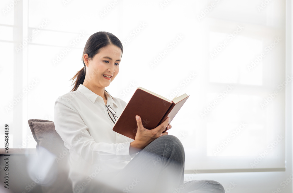 Fototapeta premium Portrait of mature woman with book indoors at home, reading.