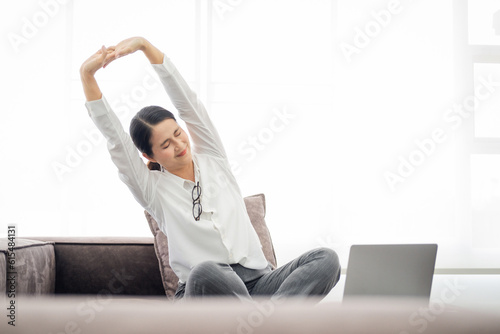 Asian Adult woman with laptop relaxing on sofa at home