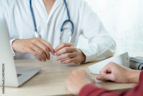 Doctor and patient discussing something while sitting at the table .