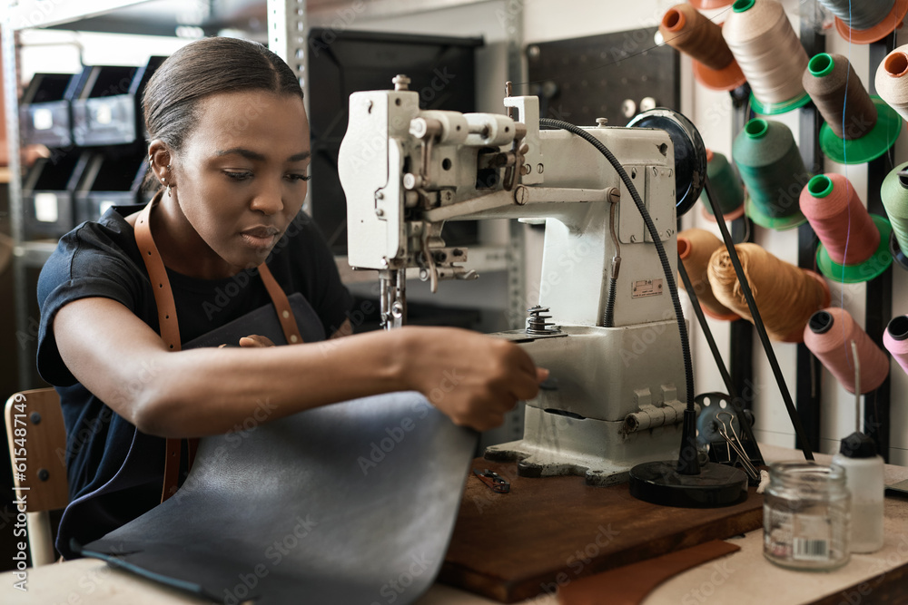 Young African female artisan sewing leather in her workshop Young African female artisan sewing leather in her workshop
