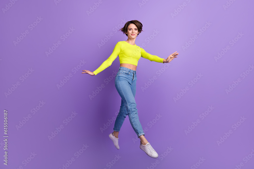 Full length photo of active carefree lovely person jumping running have good mood isolated on violet color background
