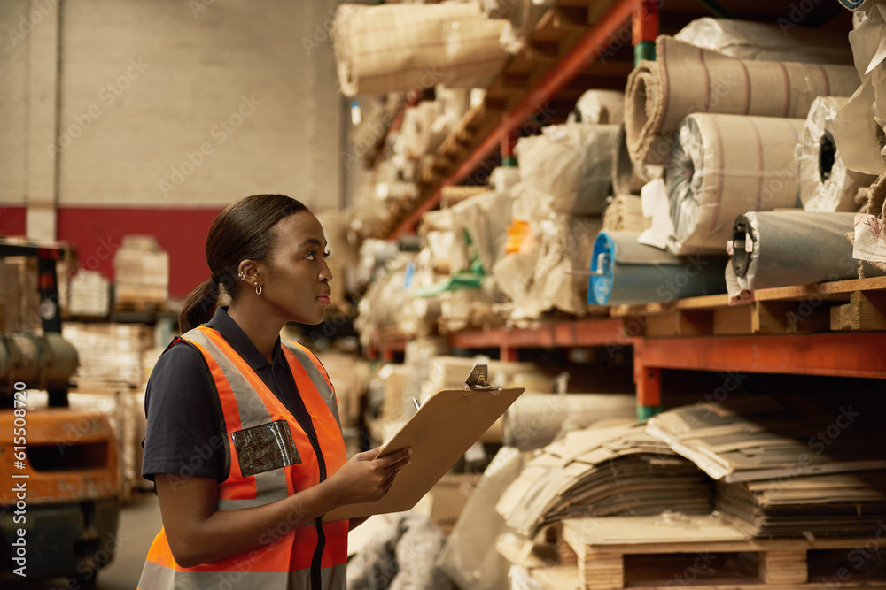 Young African female warehouse worker checking stock on shelves
