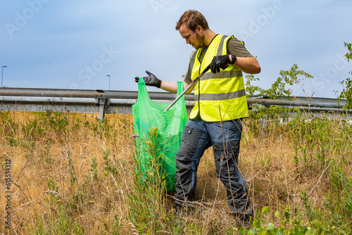 Young volunteer picking up litter in the nature