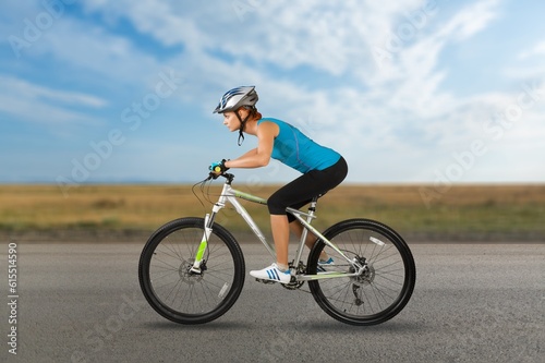 Young woman ride a bicycle on nature background