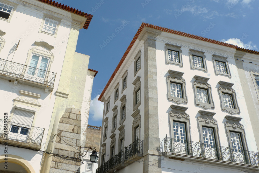 Traditional Portuguese houses with white facades and authentic windows on Giraldo square, Evora, Alentejo, Portugal