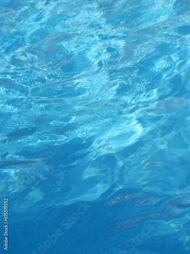 Fototapeta Naklejka Na Ścianę i Meble -  Surface of blue swimming pool at summertime. Backdrop and background of smooth clean water