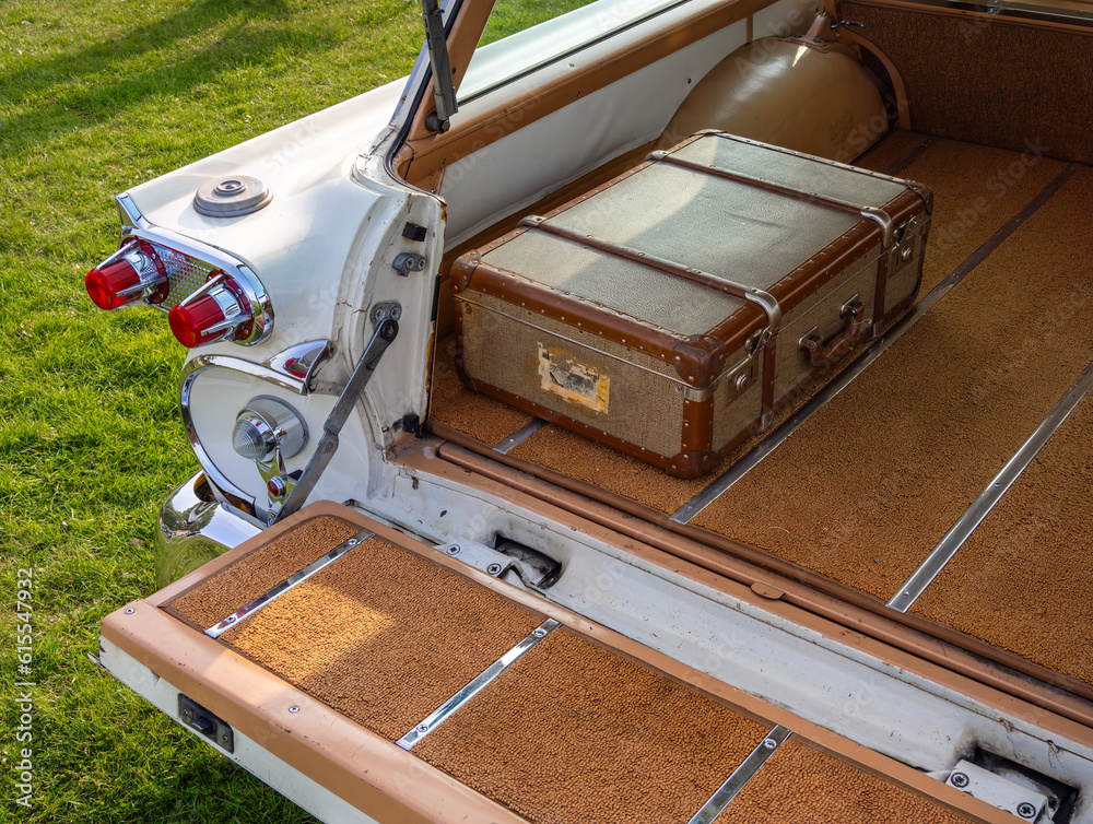 An antique suitcase in the trunk of an American oldtimer car