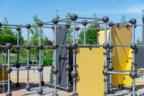 Outdoor sports ground in the city park. Street exercise equipment with horizontal bars, columns and balances. Street gym for all active people. Concept of fitness and healthy lifestyle. Details metal.