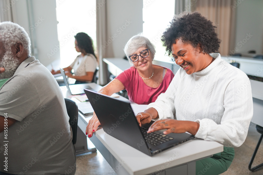 Latin women using a laptop computer during class in a class for adults and seniors at an educational institution in Brazil Latin women using a laptop computer during class in a class for adults and seniors at an educational institution in Brazil