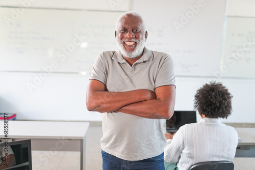 retrato de um homem negro Brasileiro de cabelos e barba brancos sorrindo de braços cruzados na sala de aula em um curso para adultos no Brasil photo