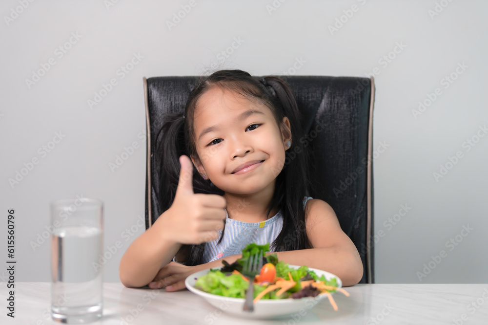 Little asian cute girl to eat healthy vegetables.Nutrition and healthy eating habits for kids concept.Children happy and like to eat vegetables. Little asian cute girl to eat healthy vegetables.Nutrition and healthy eating habits for kids concept.Children happy and like to eat vegetables.