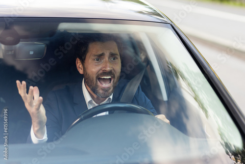 Obraz na plátně Angry male car driver yells at other drivers and pedestrians who obstruct traffi