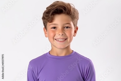 Portrait of a smiling boy in a purple t-shirt on a white background.