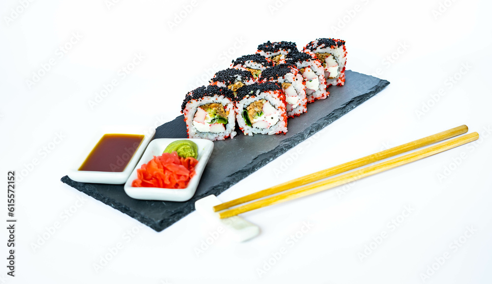 Sushi rolls on a black slate plate with soy sauce, ginger and wasabi. Japanese food, eating healthy Sushi rolls on a black slate plate with soy sauce, ginger and wasabi. Japanese food, eating healthy