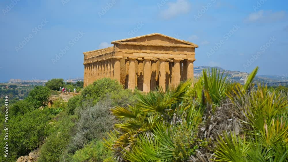 View of the Temple of Concordia in Agrigento with green grass foreground. Ancient, preserved Greek temple on a hill, with Doric architecture and historical constructions in Sicily, Italy.