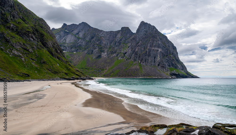 Sandy beach surrounded by mountains on the sea coast - Kvalvika Beach, Lofoten, Norway