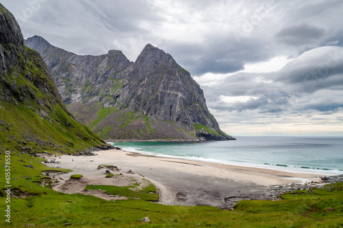 Sandy beach surrounded by mountains on the sea coast - Kvalvika Beach  Lofoten  Norway