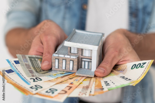man with white hair and money on her hands in her home on a sunny day