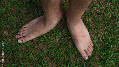 pies de adulto joven con las uñas pintadas, descalzo en el jardin y se tomo con luz natural mas filtro polarizador photo