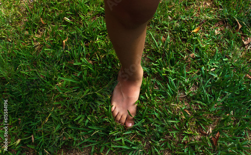 pie derecho de niño descalzo en el pasto, se tomo con luz natural y filtro polarizador photo