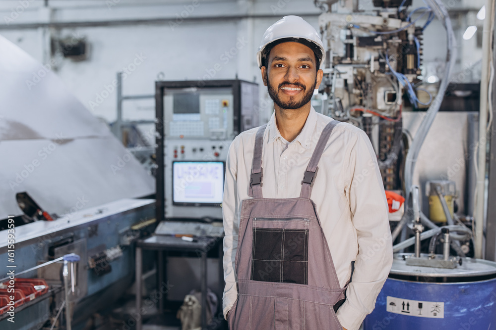 Operator of machine. Industrial worker indoors in factory. Young technician in white hard hat. Operator of machine. Industrial worker indoors in factory. Young technician in white hard hat.