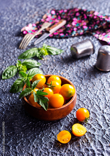 Fresh ripe yellow tomatoes on dark table outdoors, closeup