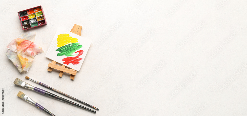 Small drawing easel, paints and brushes on white background with space for text Small drawing easel, paints and brushes on white background with space for text