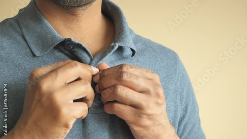 Man buttoning his shirt close up photo