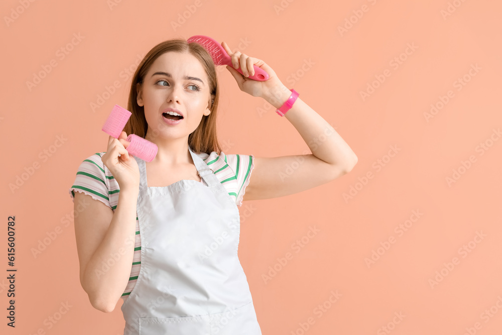 Female hairdresser with curlers and brush on pink background Female hairdresser with curlers and brush on pink background