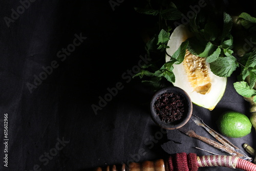 bowl of tobacco for hookah. smoking shisha. berries and fruits on a black background