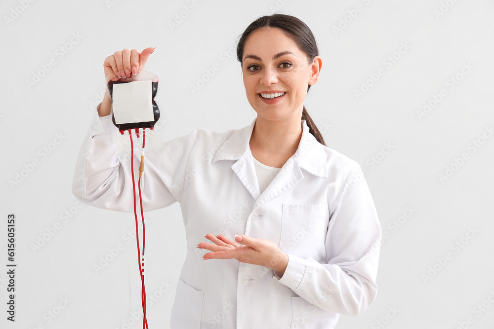 Female doctor with blood pack for transfusion on light background Female doctor with blood pack for transfusion on light background